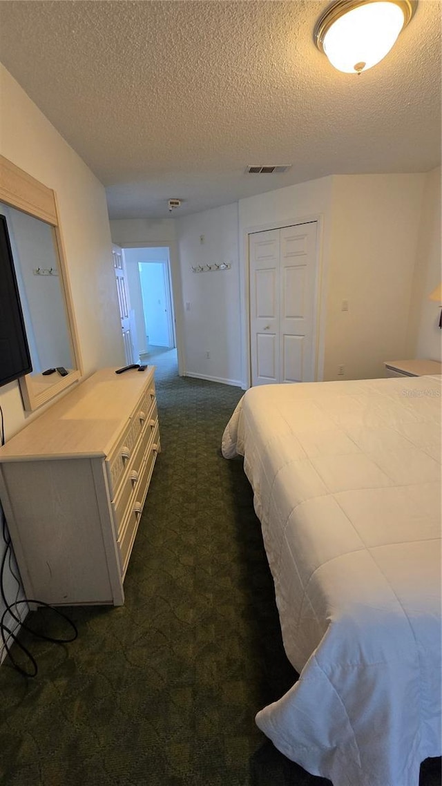 carpeted bedroom with a closet and a textured ceiling