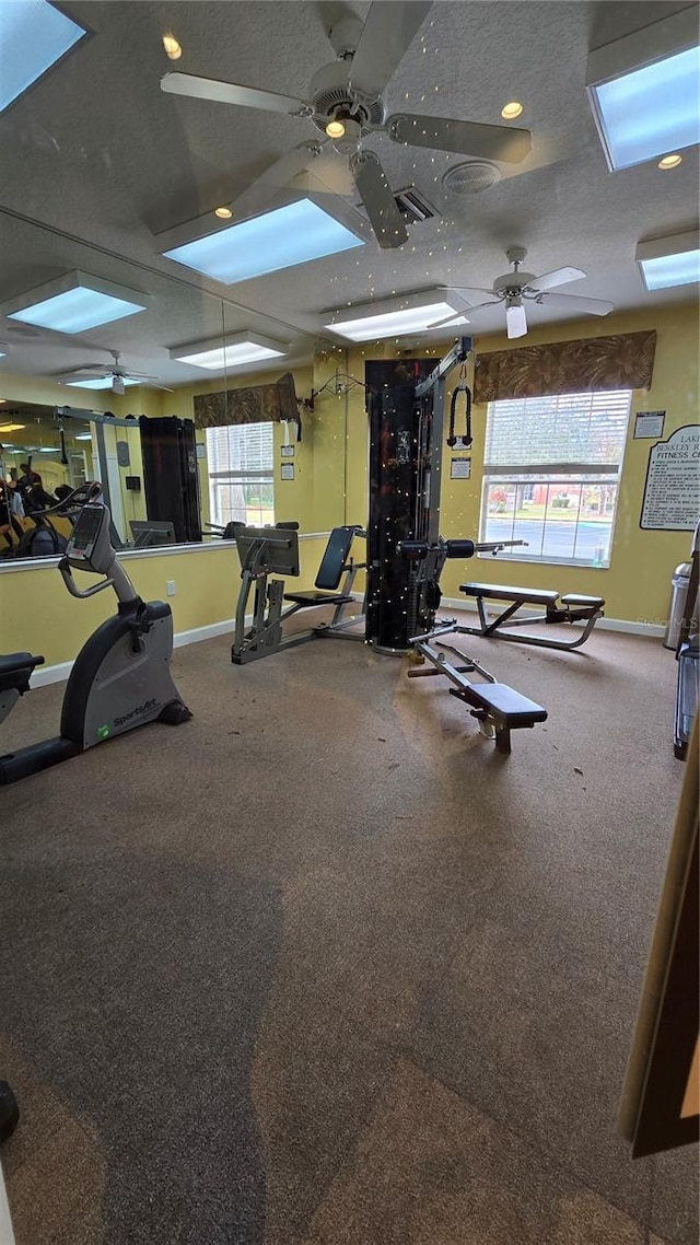 gym with a textured ceiling and ceiling fan