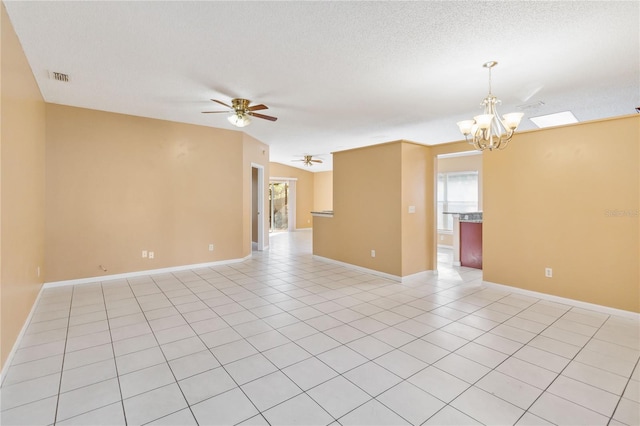 unfurnished room featuring light tile patterned floors, ceiling fan with notable chandelier, and a textured ceiling