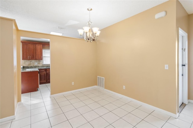 unfurnished dining area with a chandelier and light tile patterned flooring