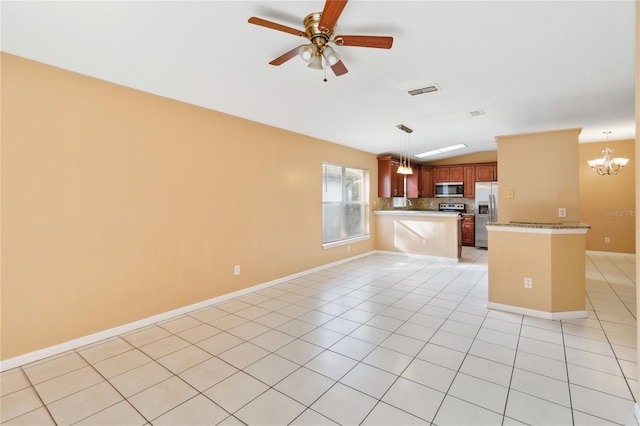 kitchen with light tile patterned flooring, appliances with stainless steel finishes, decorative light fixtures, and kitchen peninsula