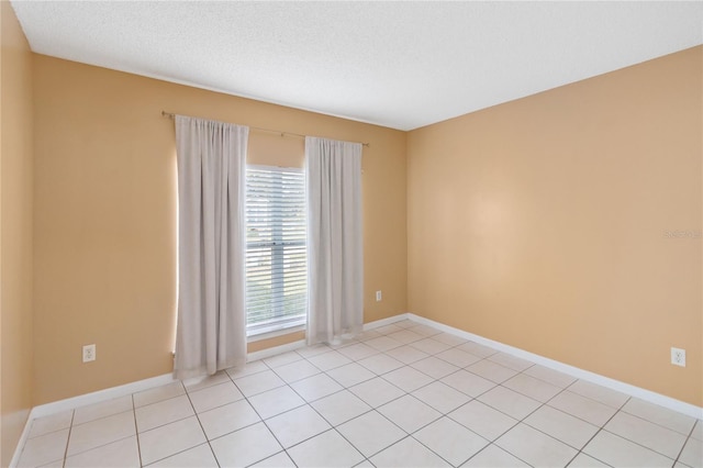 unfurnished room with light tile patterned floors and a textured ceiling