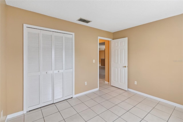 unfurnished bedroom featuring a closet and light tile patterned floors