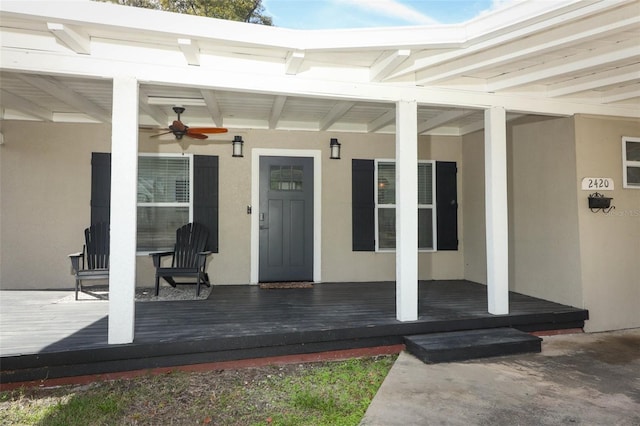 entrance to property featuring a deck and ceiling fan