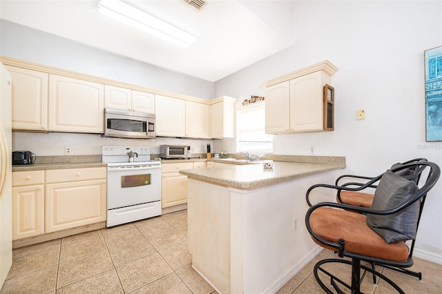 kitchen featuring white electric stove, sink, a breakfast bar area, light tile patterned floors, and kitchen peninsula