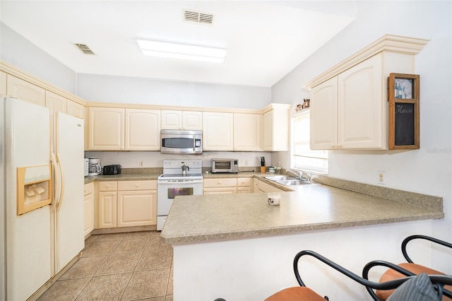 kitchen with sink, light tile patterned floors, white appliances, and kitchen peninsula