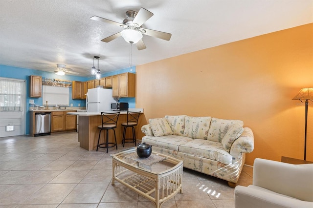 living room featuring light tile patterned floors, a textured ceiling, sink, and ceiling fan