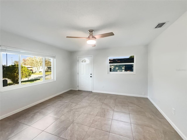 tiled empty room with ceiling fan