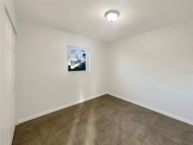 unfurnished room with a textured ceiling