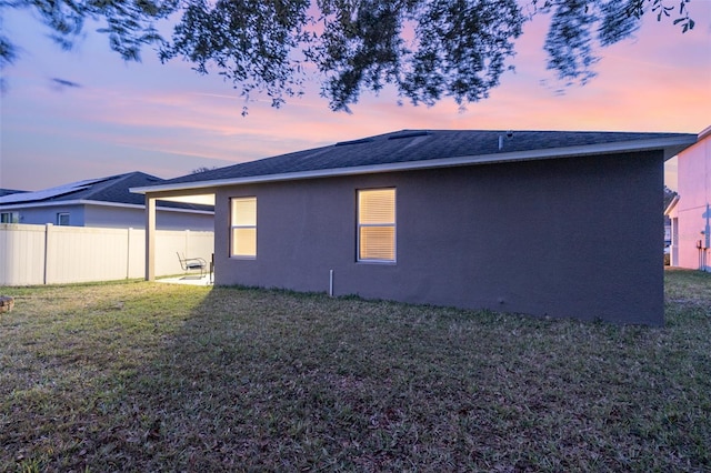 property exterior at dusk with a yard