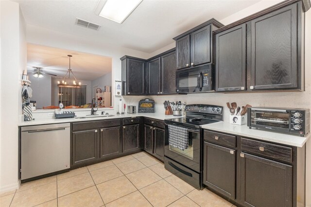 kitchen featuring sink, decorative light fixtures, a chandelier, light tile patterned floors, and black appliances