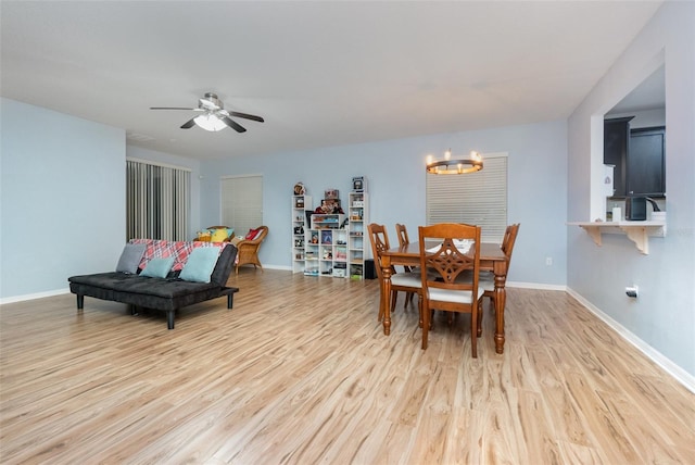 dining space featuring ceiling fan with notable chandelier and light hardwood / wood-style floors