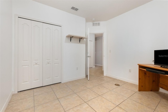 unfurnished bedroom with light tile patterned flooring and a closet