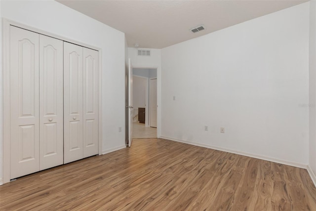 unfurnished bedroom featuring a closet and light wood-type flooring