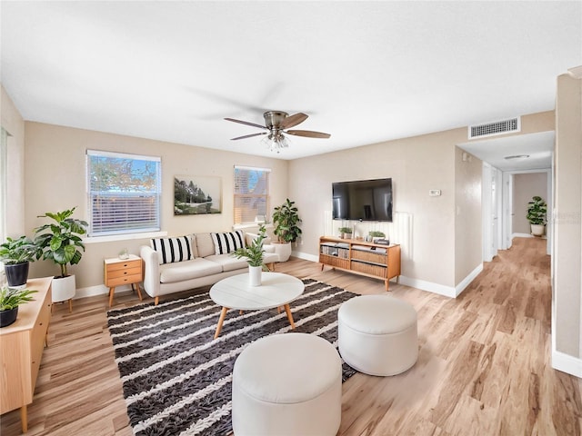 living room featuring ceiling fan and light hardwood / wood-style flooring