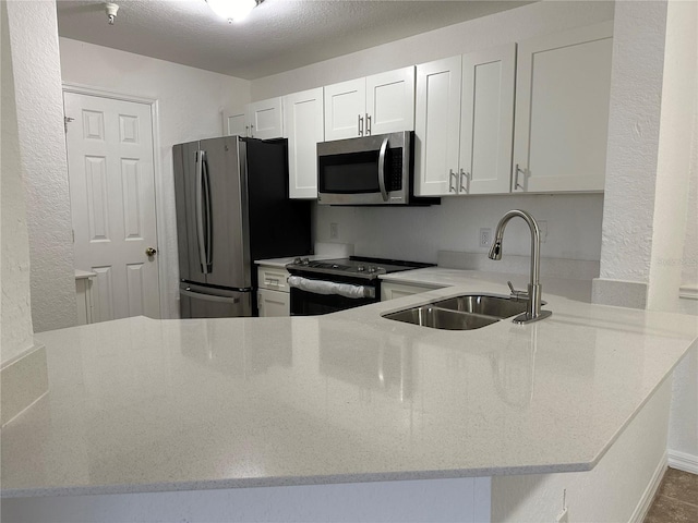 kitchen featuring white cabinetry, sink, stainless steel appliances, and kitchen peninsula