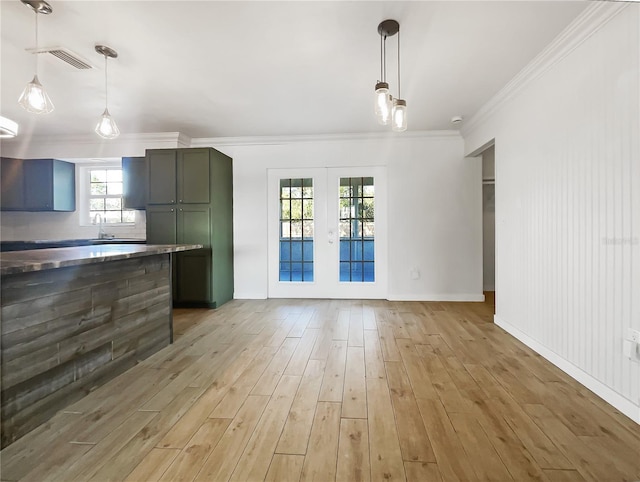 interior space with french doors, ornamental molding, hanging light fixtures, and light hardwood / wood-style flooring