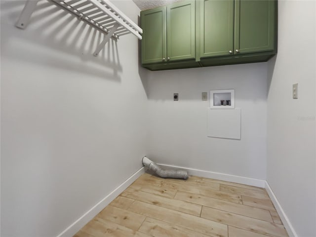 laundry area featuring electric dryer hookup, washer hookup, cabinets, and light wood-type flooring