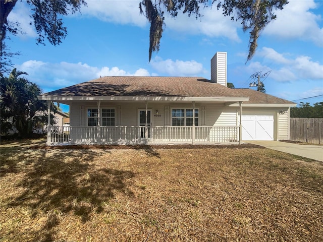 single story home featuring a garage, a porch, and a front yard