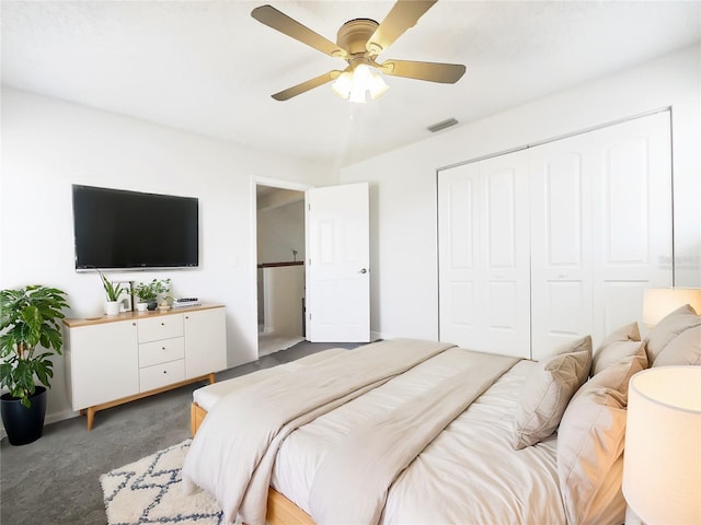 bedroom featuring ceiling fan, dark carpet, and a closet