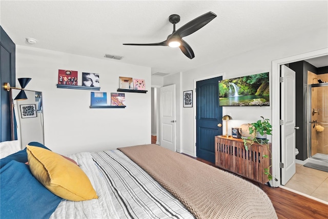 bedroom featuring wood finished floors, visible vents, and a ceiling fan