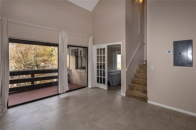 doorway to outside with electric panel and high vaulted ceiling