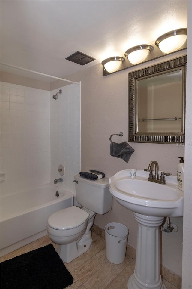 bathroom featuring tub / shower combination and toilet