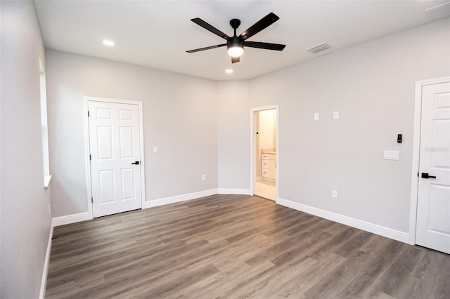 empty room with ceiling fan and dark hardwood / wood-style flooring