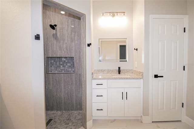 bathroom with vanity and tiled shower