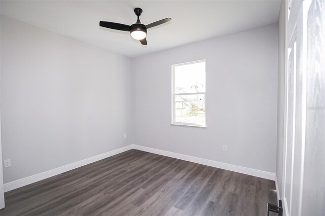 spare room with dark wood-type flooring and ceiling fan