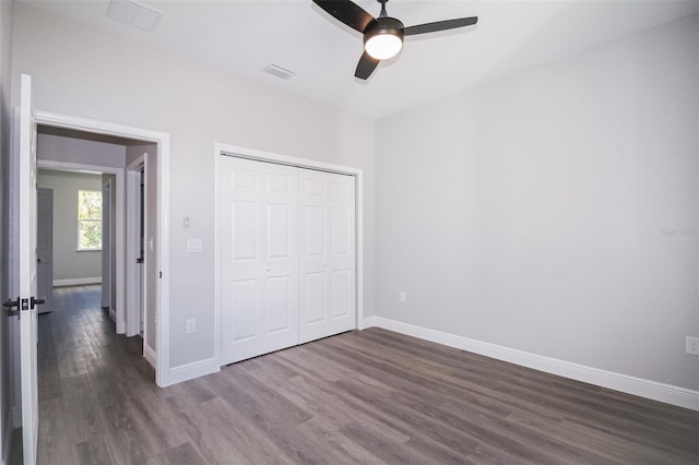 unfurnished bedroom with dark hardwood / wood-style floors, ceiling fan, and a closet