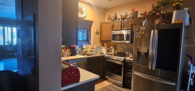 kitchen featuring tasteful backsplash, appliances with stainless steel finishes, and light wood-type flooring