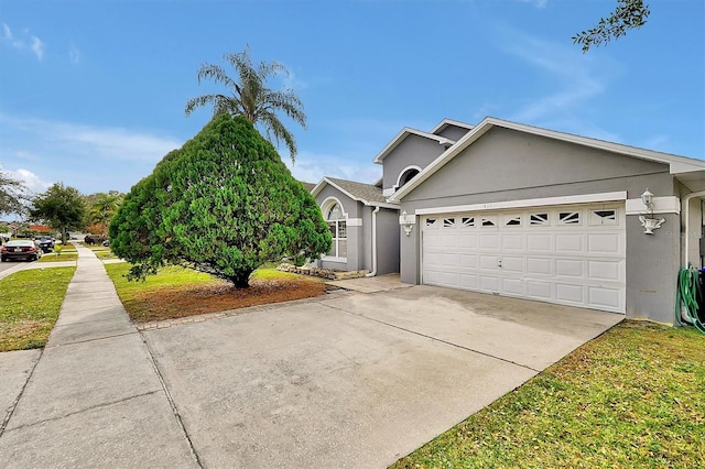 view of front facade with concrete driveway, an attached garage, and stucco siding