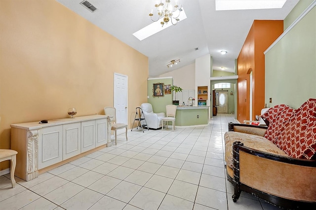 tiled living room with sink, lofted ceiling with skylight, and a chandelier