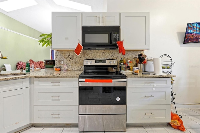 kitchen with sink, white cabinetry, light stone counters, stainless steel electric range, and light tile patterned floors