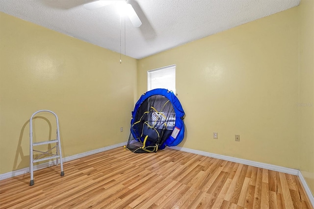 miscellaneous room featuring ceiling fan, a textured ceiling, and light hardwood / wood-style floors