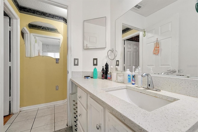 bathroom featuring visible vents, baseboards, tile patterned flooring, a textured ceiling, and vanity