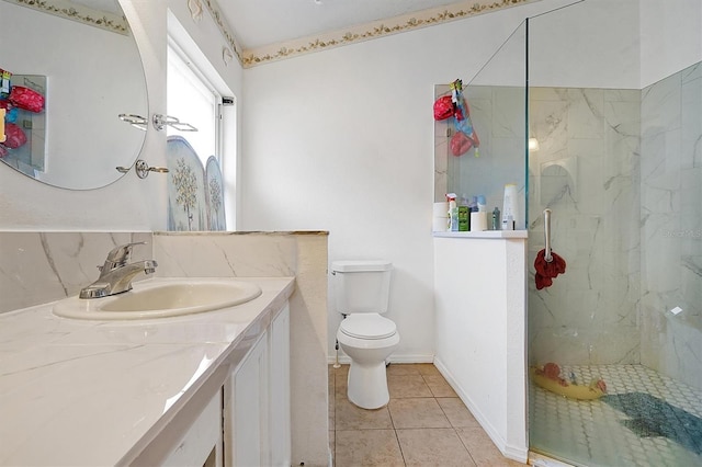 full bathroom with a marble finish shower, toilet, vanity, tile patterned flooring, and baseboards