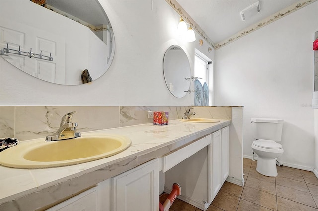 bathroom featuring vanity, toilet, tile patterned floors, and decorative backsplash