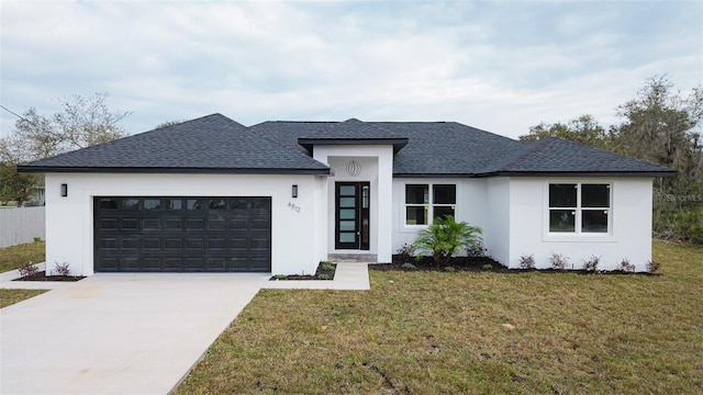 prairie-style house featuring a garage and a front lawn