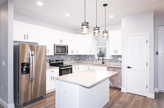 kitchen with white cabinetry, appliances with stainless steel finishes, a center island, and sink