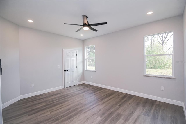 empty room featuring dark wood-type flooring, ceiling fan, and plenty of natural light