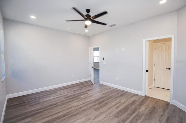 spare room with dark hardwood / wood-style floors and ceiling fan