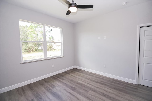 unfurnished room featuring dark wood-type flooring and ceiling fan