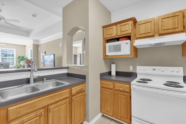 kitchen with sink, white appliances, light tile patterned floors, a tray ceiling, and ceiling fan