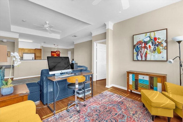 living room with hardwood / wood-style flooring, ceiling fan, crown molding, and a raised ceiling