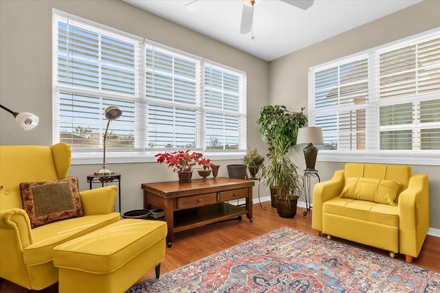 living area featuring wood-type flooring and ceiling fan