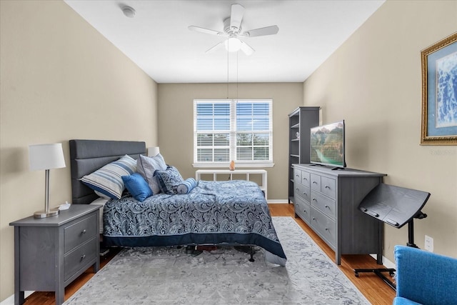 bedroom featuring ceiling fan, radiator heating unit, and light wood-type flooring