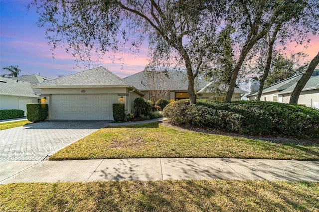 view of front of property featuring a garage and a lawn