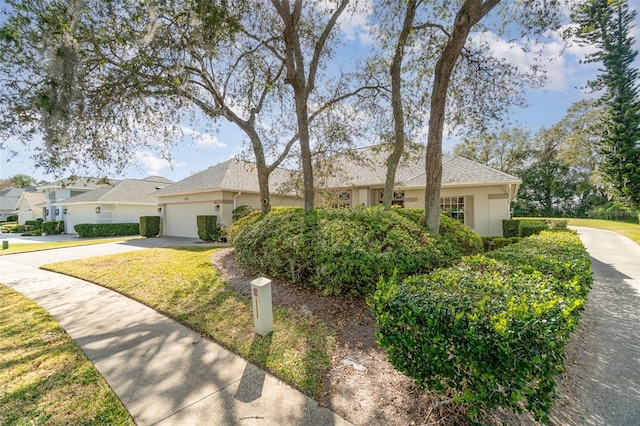 single story home featuring a garage and a front lawn